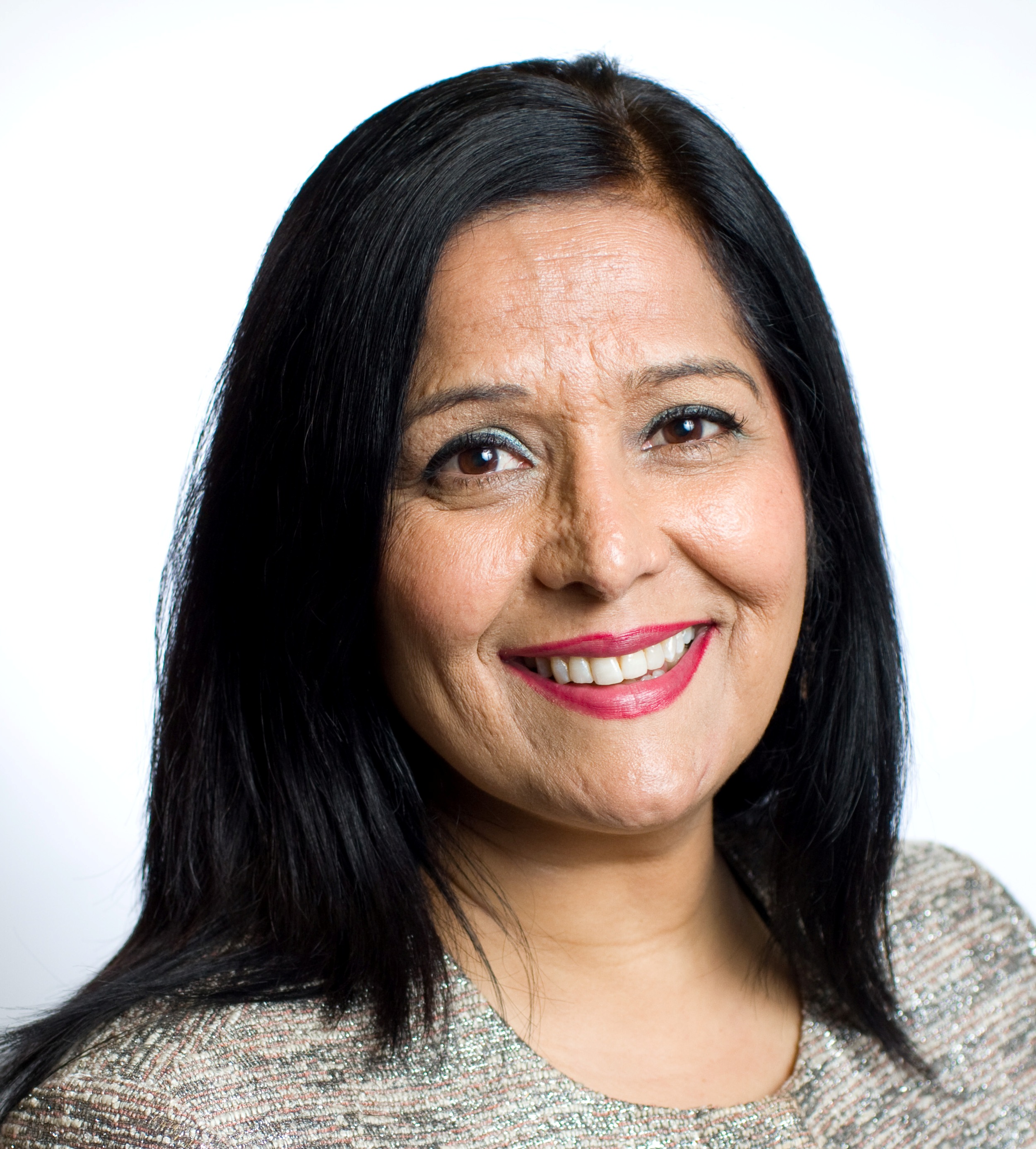 Photograph of Yasmin Qureshi, Labour Member of Parliament for Bolton South East, on a background of Bolton Town Hall and a Union Flag