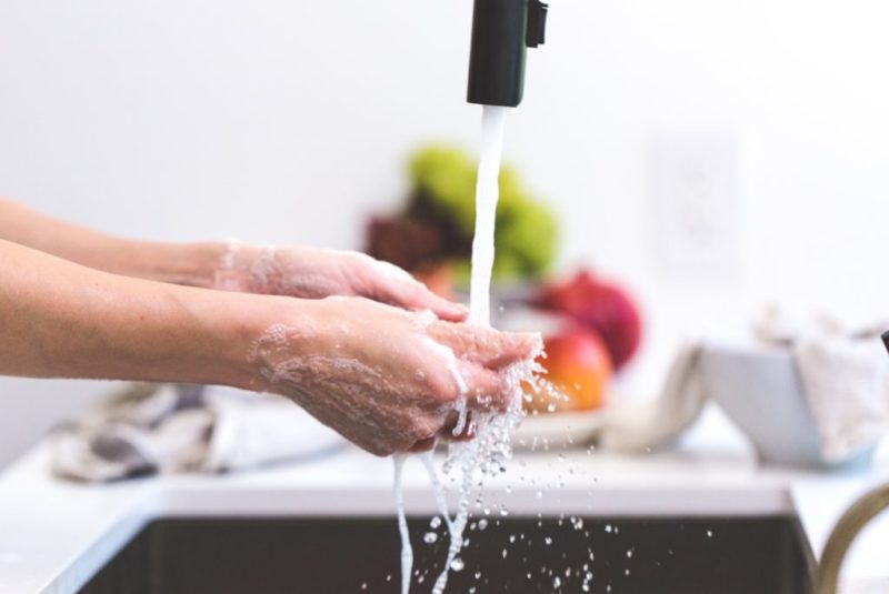 A photograph of a person washing their hands