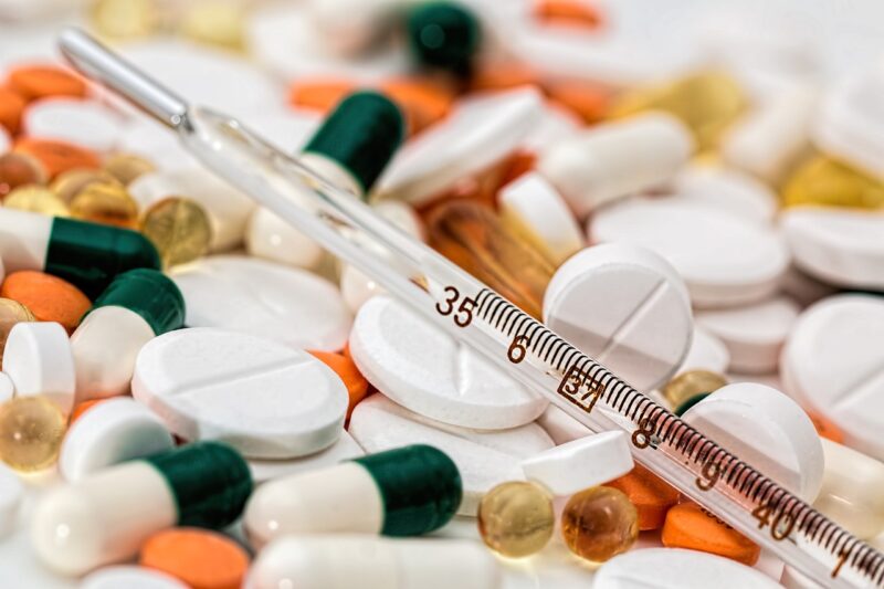 Photograph of pills, tablets and a syringe.