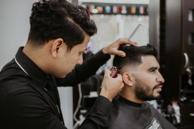 Image shows a  barber cutting a man